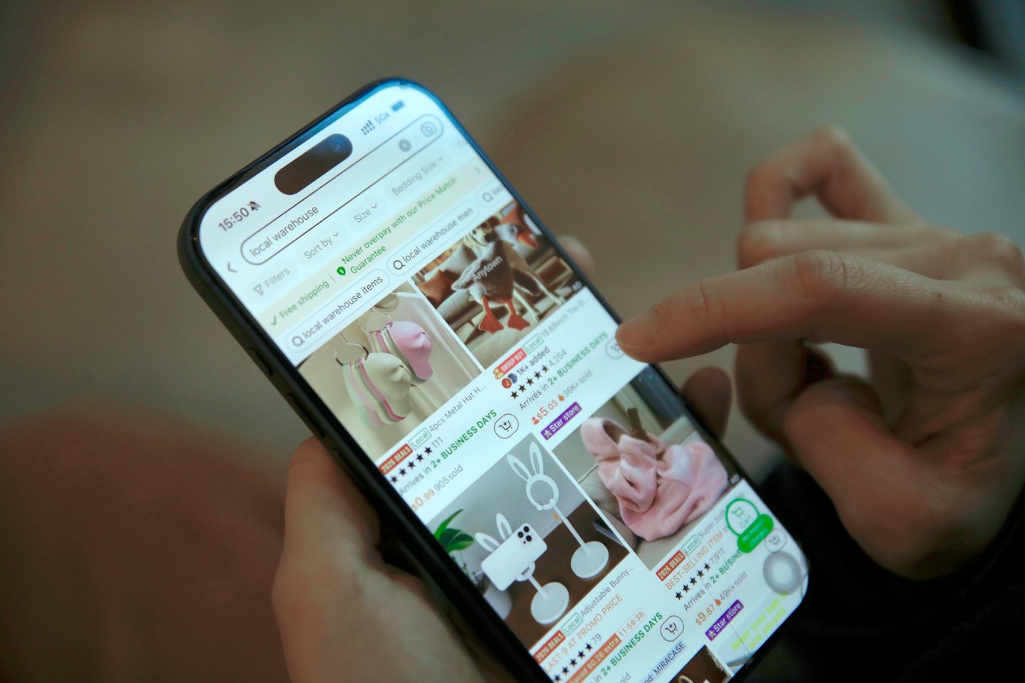 Hands tapping an online shopping app on a smartphone.